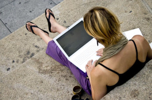 A girl working on her laptop seated on stairs
